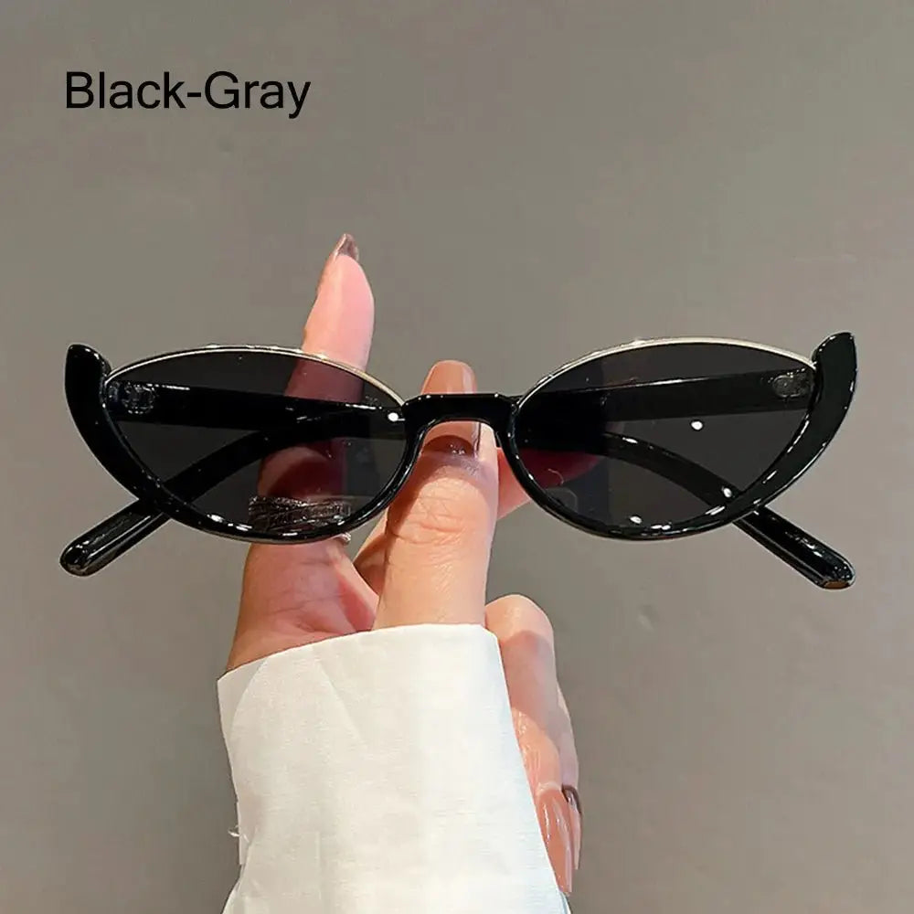 a person holding up a pair of black sunglasses