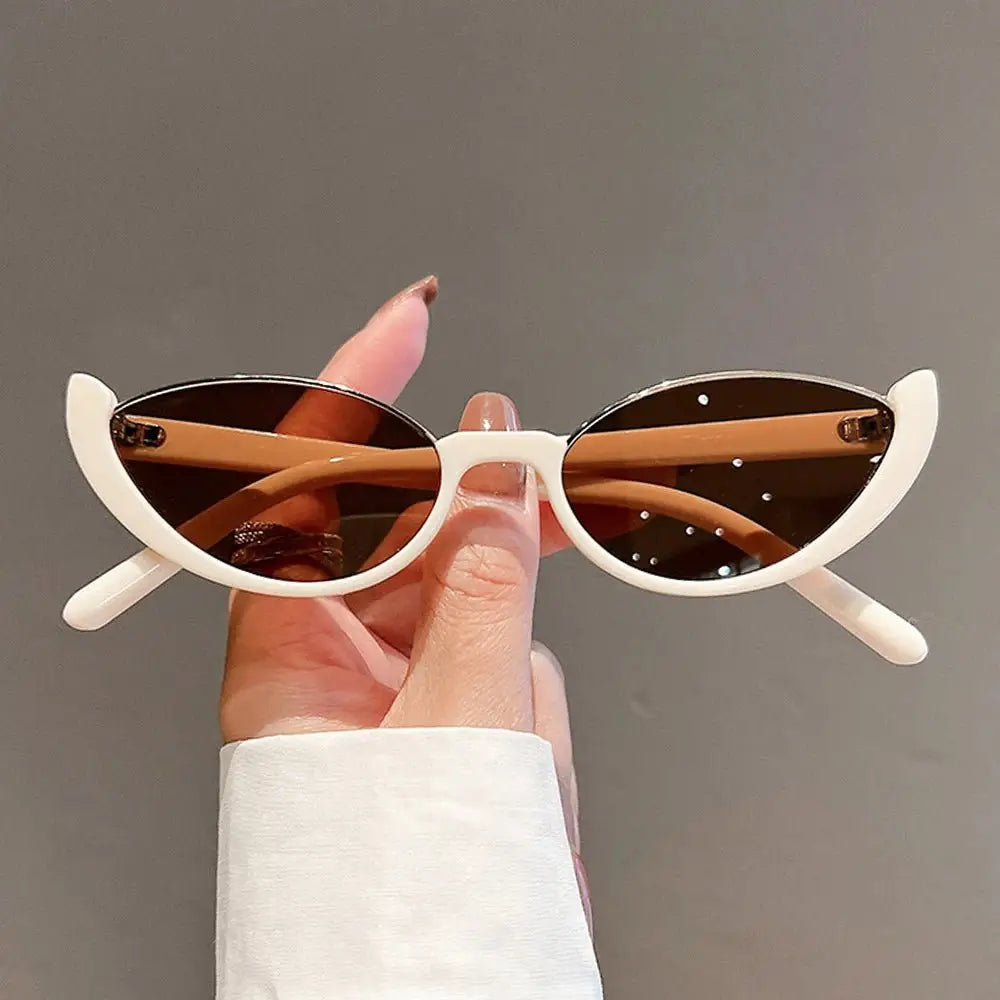 a person holding up a pair of sunglasses