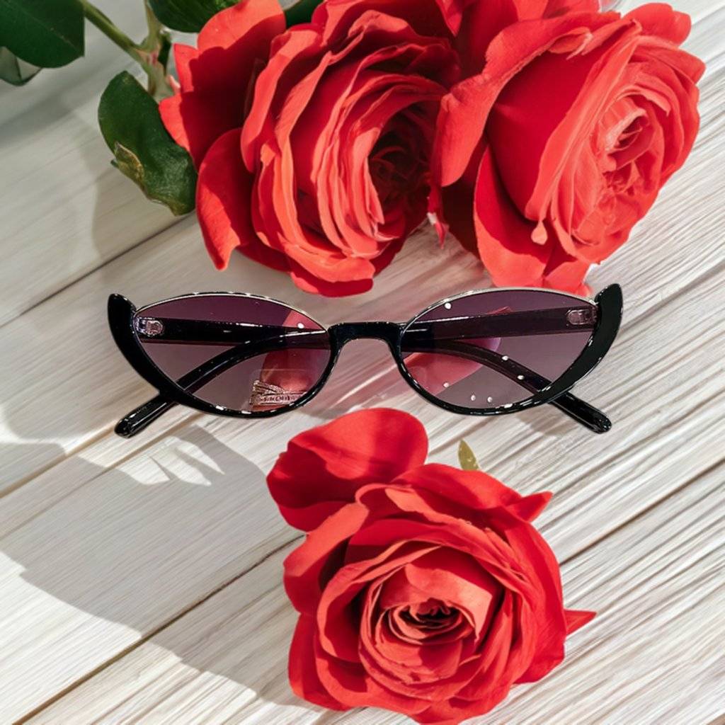 a pair of sunglasses and a rose on a table