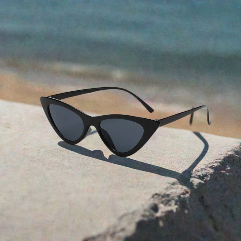 a pair of sunglasses sitting on top of a sandy beach